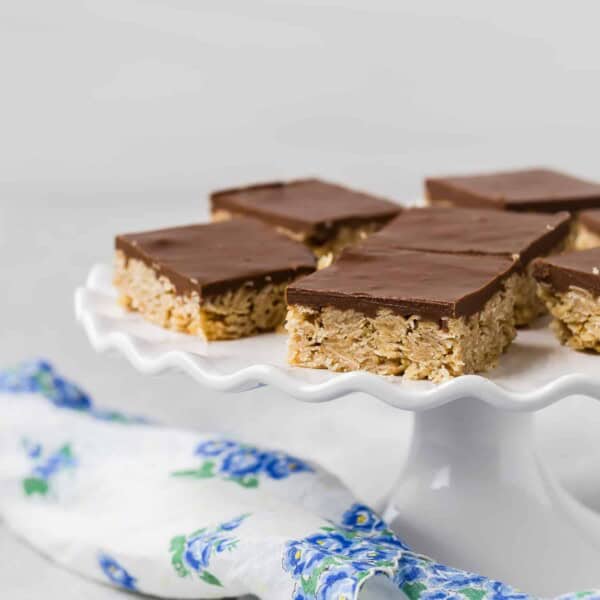 Chocolate and oat bars on a white ruffled edge cake stand.