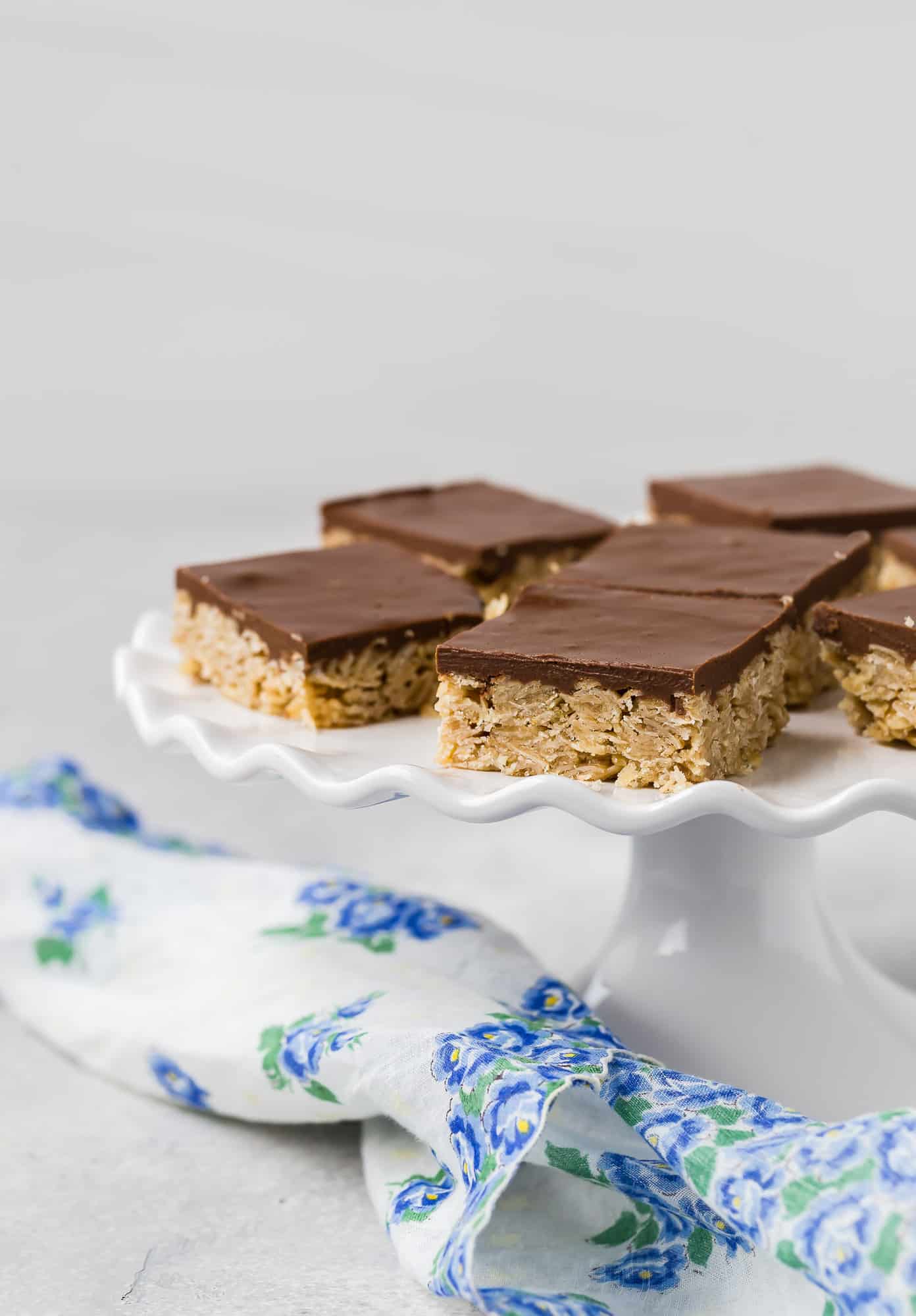 Chocolate and oat bars on a white ruffled edge cake stand.