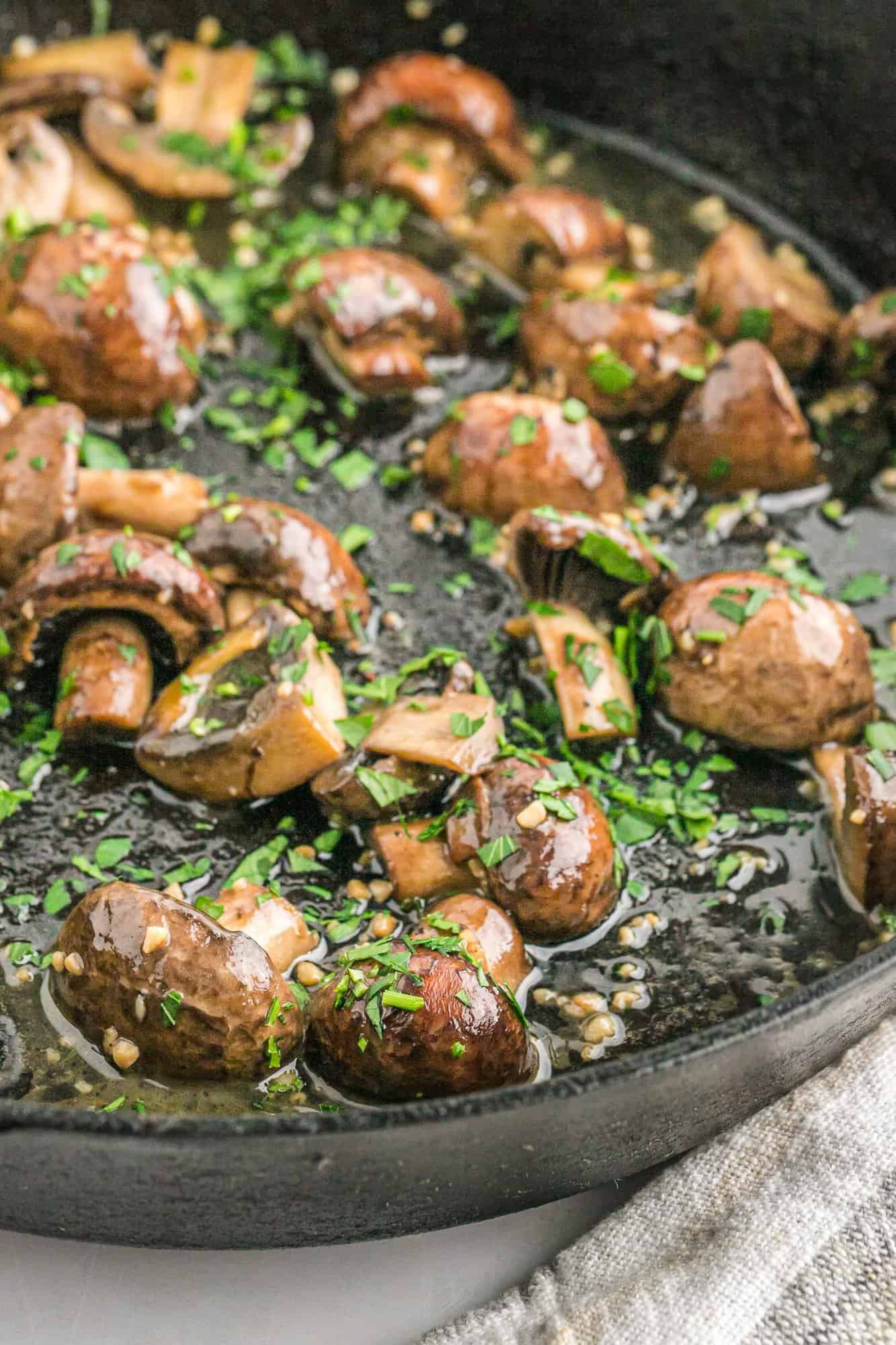 Cooked mushrooms swimming in garlic and parsley.