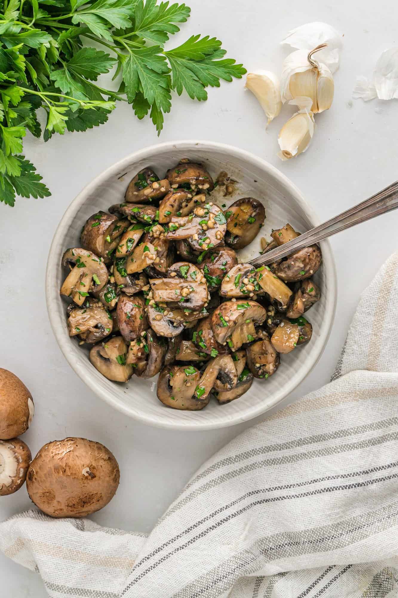 Overhead view of mushrooms in a large white bowl.