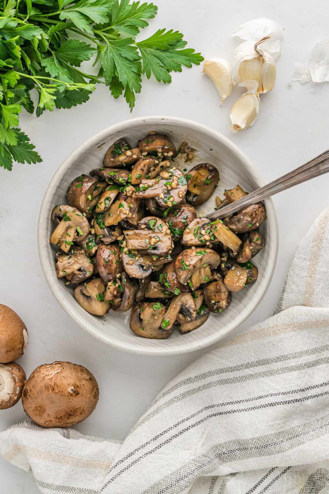 Overhead view of mushrooms in a large white bowl.