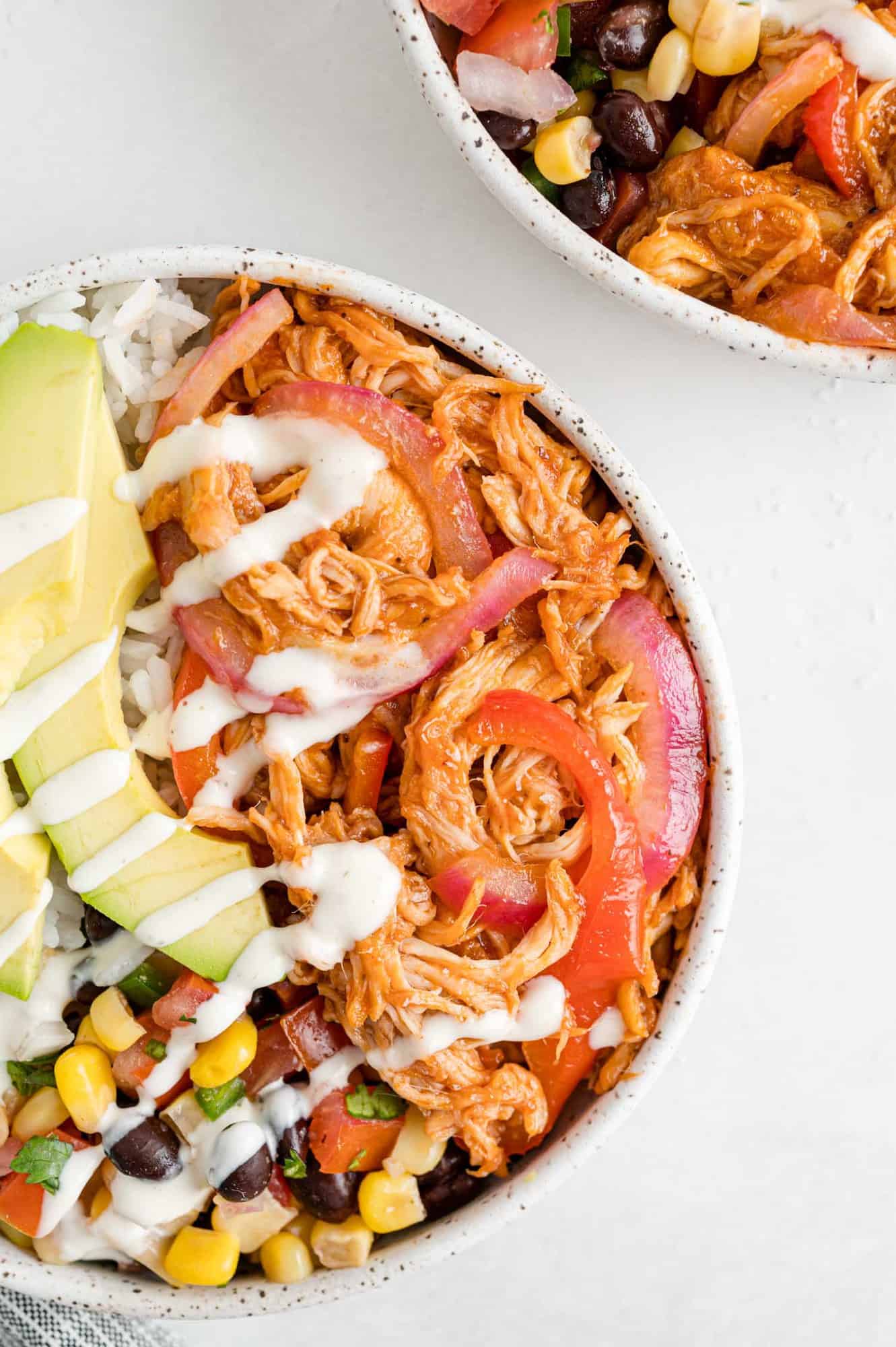 Close up of chicken and peppers and onions in a burrito bowl. 