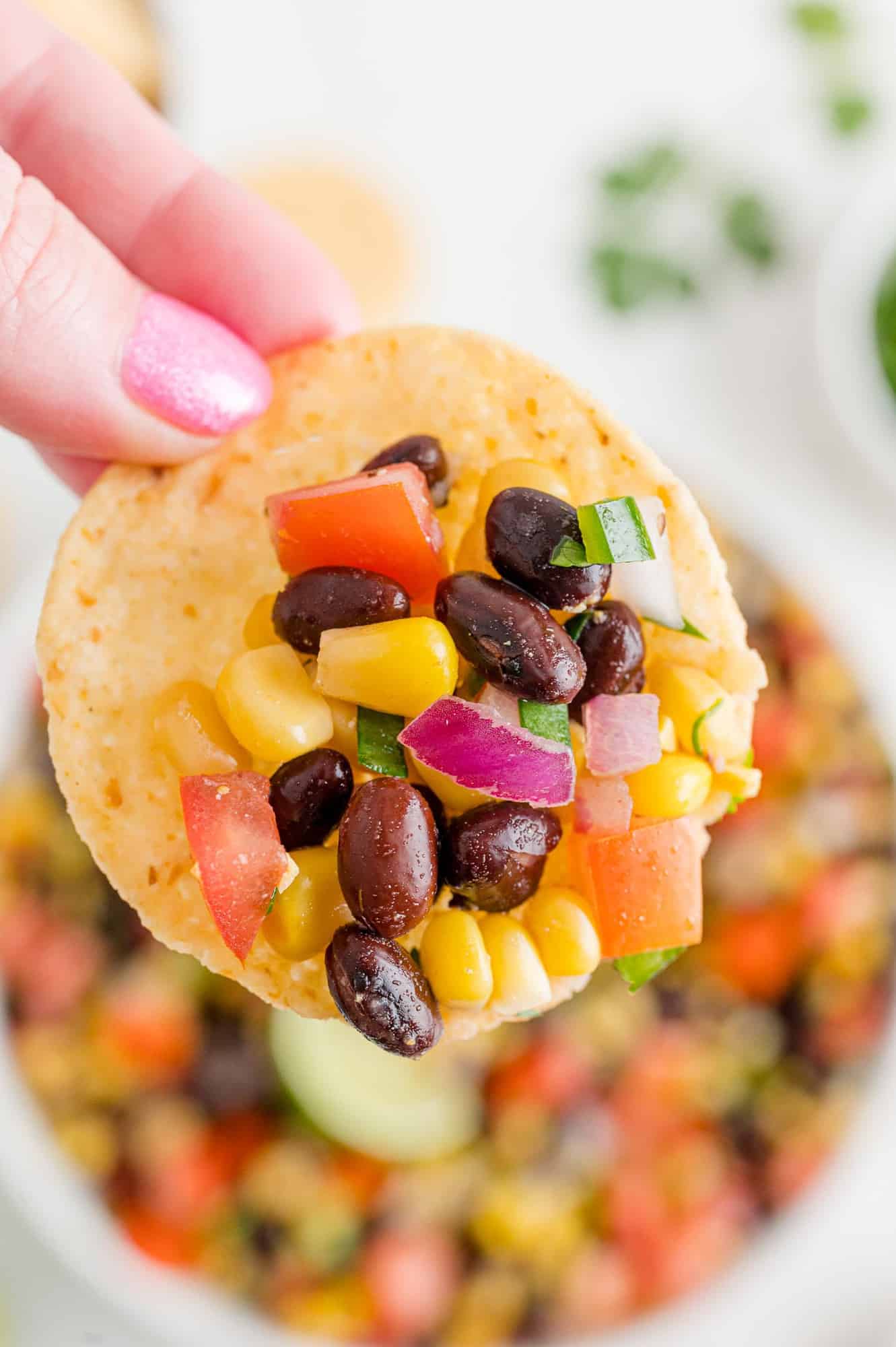 Salsa with beans and corn on a chip.