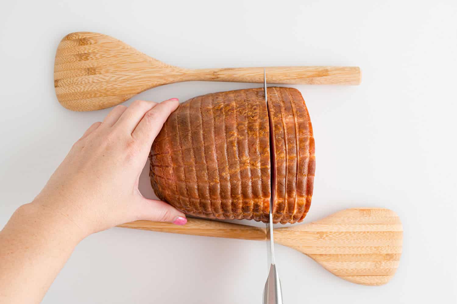 Ham being sliced hasselback style.