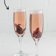 Two champagne cocktails, text overlay reads "hibiscus mimosas - so fun!"