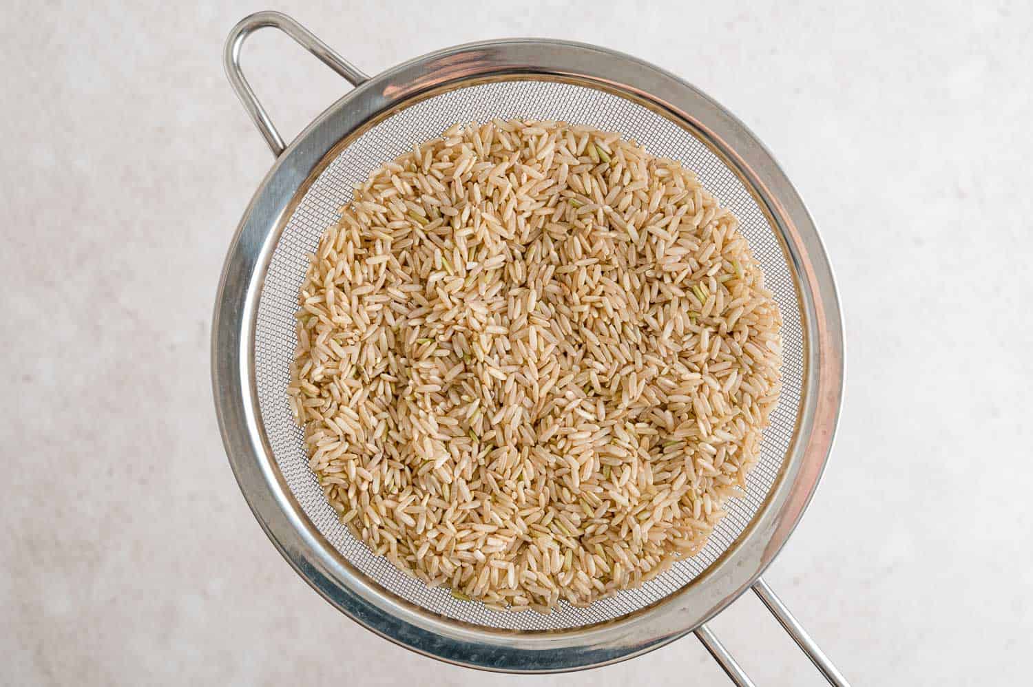 Brown rice being rinsed.