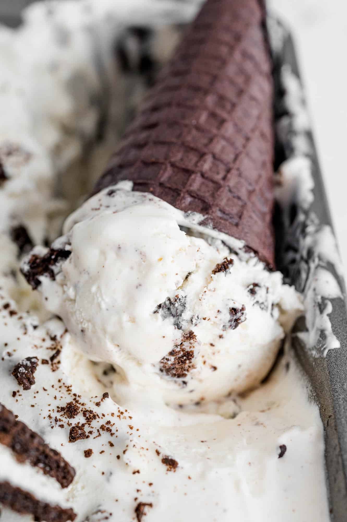 Ice cream cone in loaf pan of more ice cream.