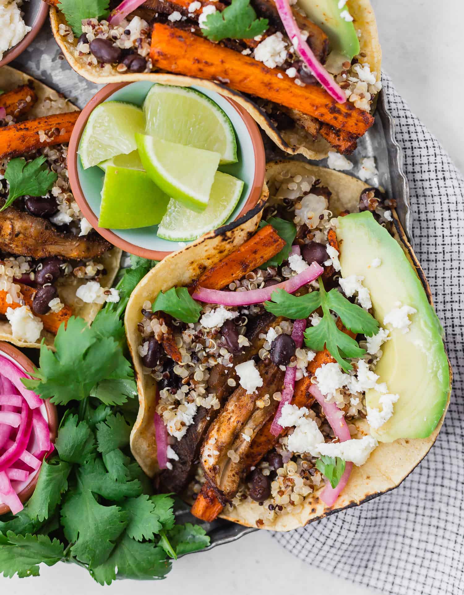 Taco on a tray with cilantro, lime, pickled onions.