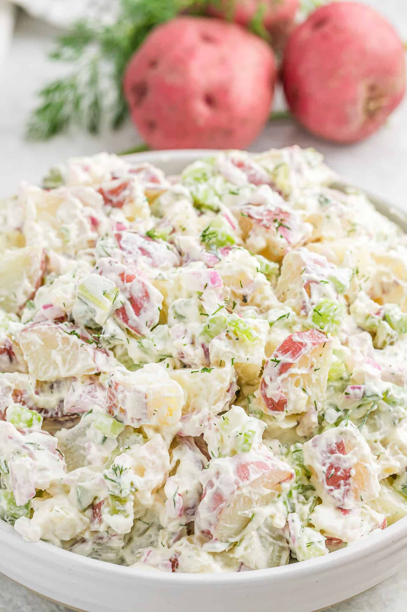 Dill potato salad in a large white bowl.