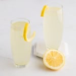 Two French 75 cocktails garnished with lemon twists.