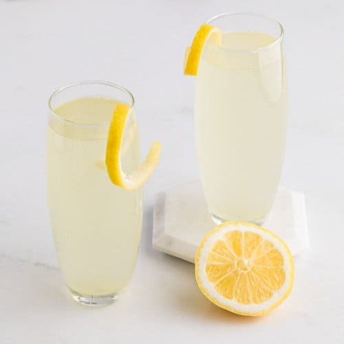 Two French 75 cocktails garnished with lemon twists.