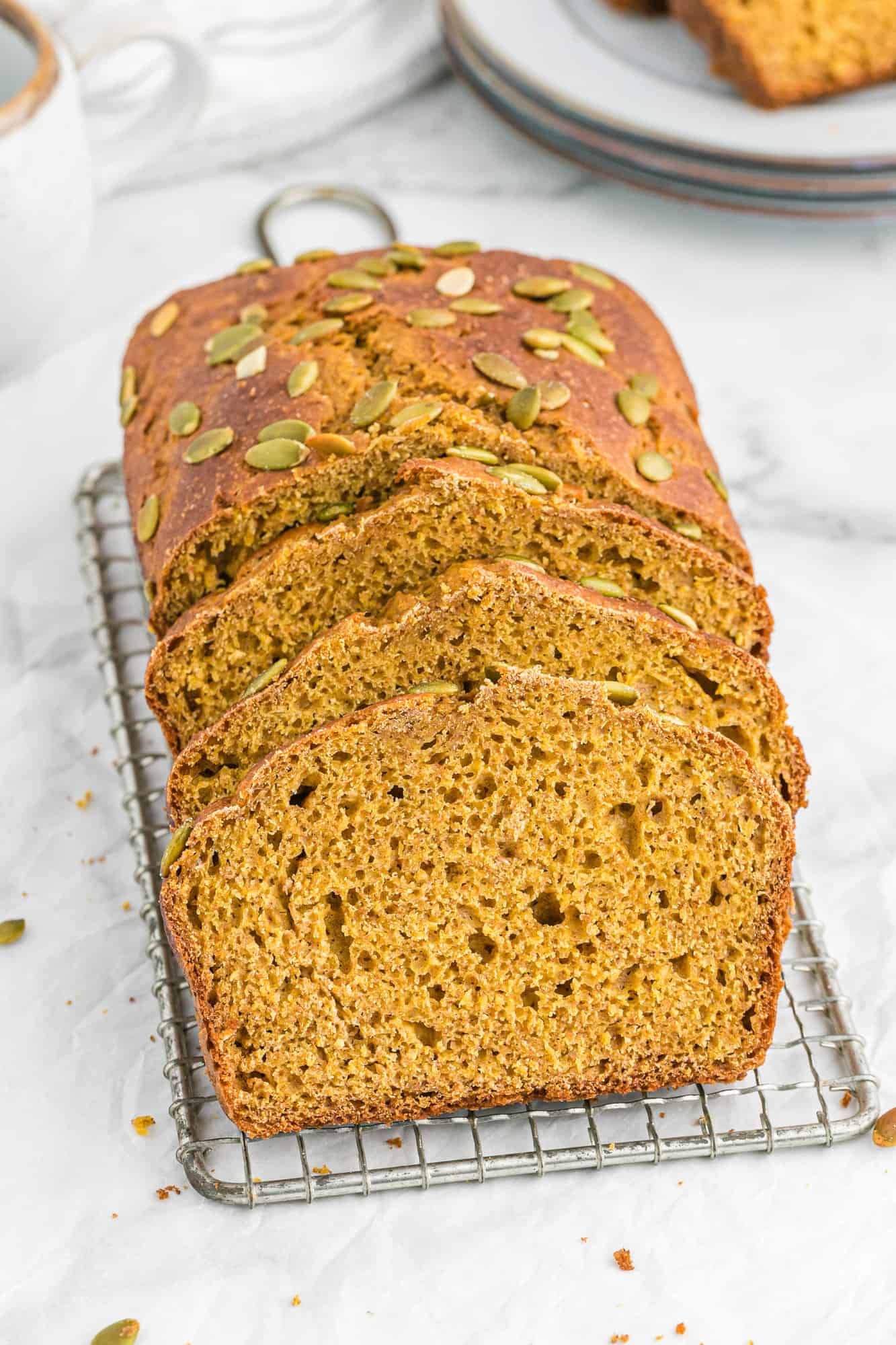 Sliced pumpkin bread on a white surface.