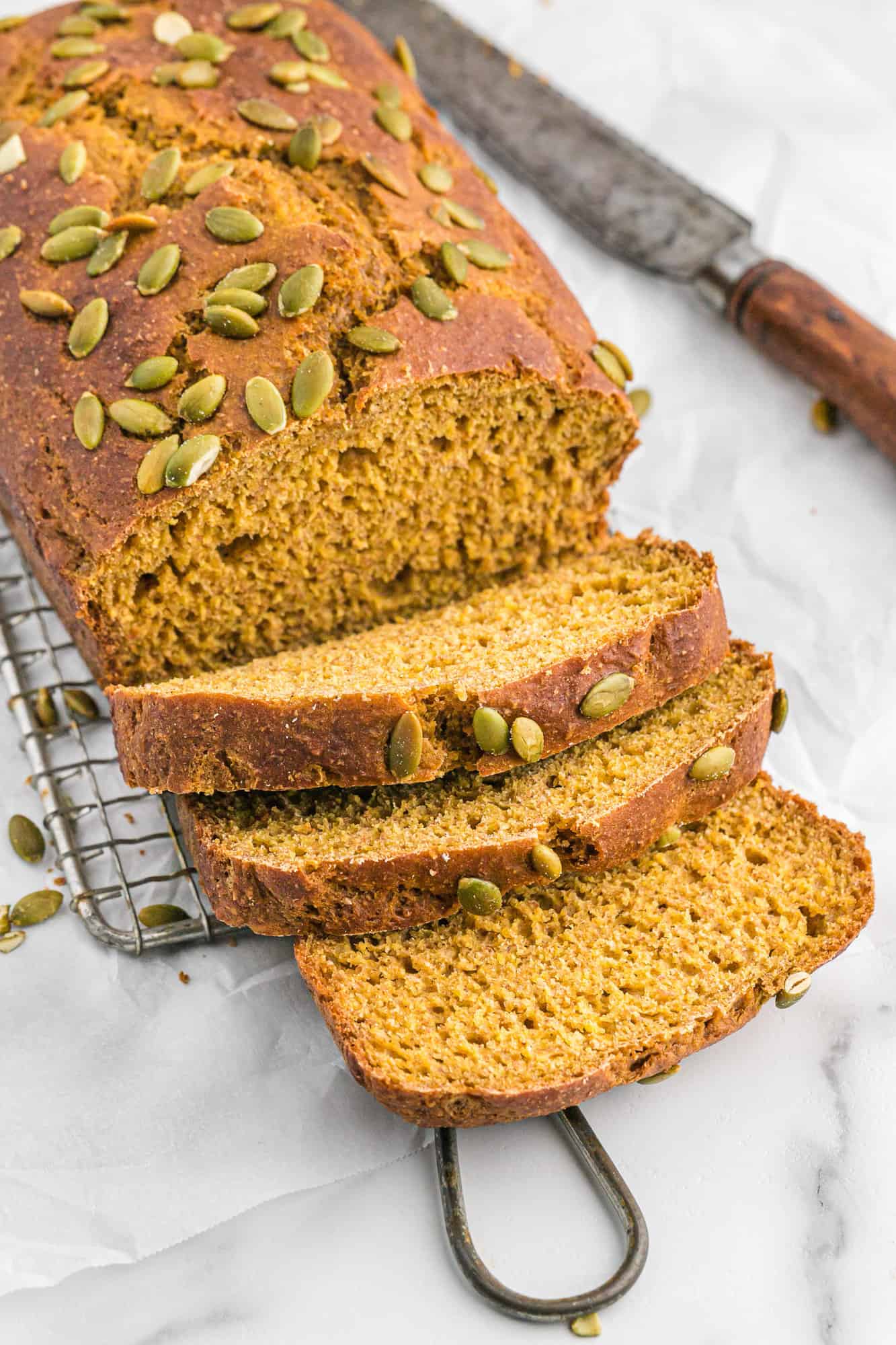 Loaf of healthy pumpkin bread, partially sliced.