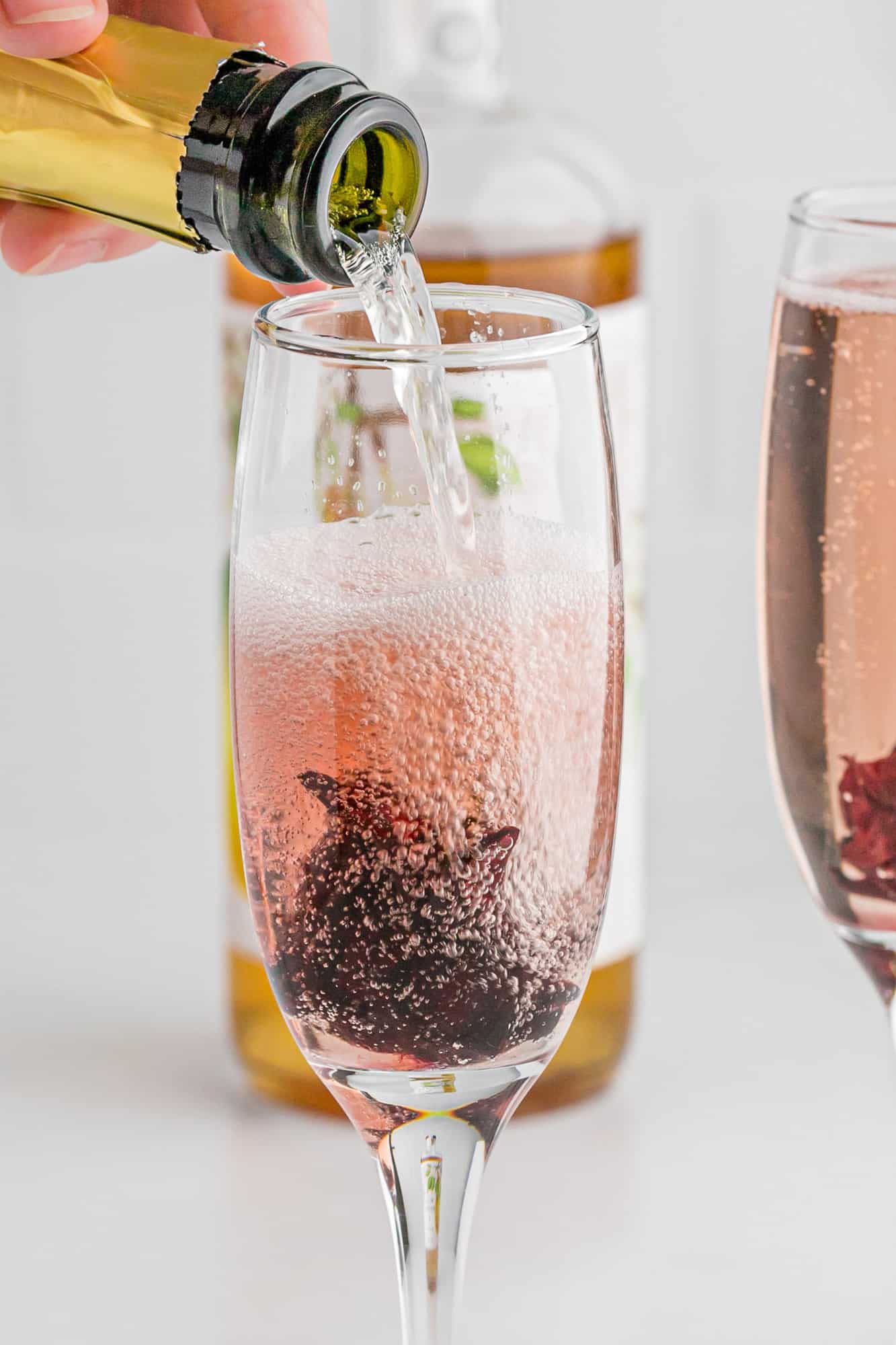 Champagne being poured into hibiscus mimosa.