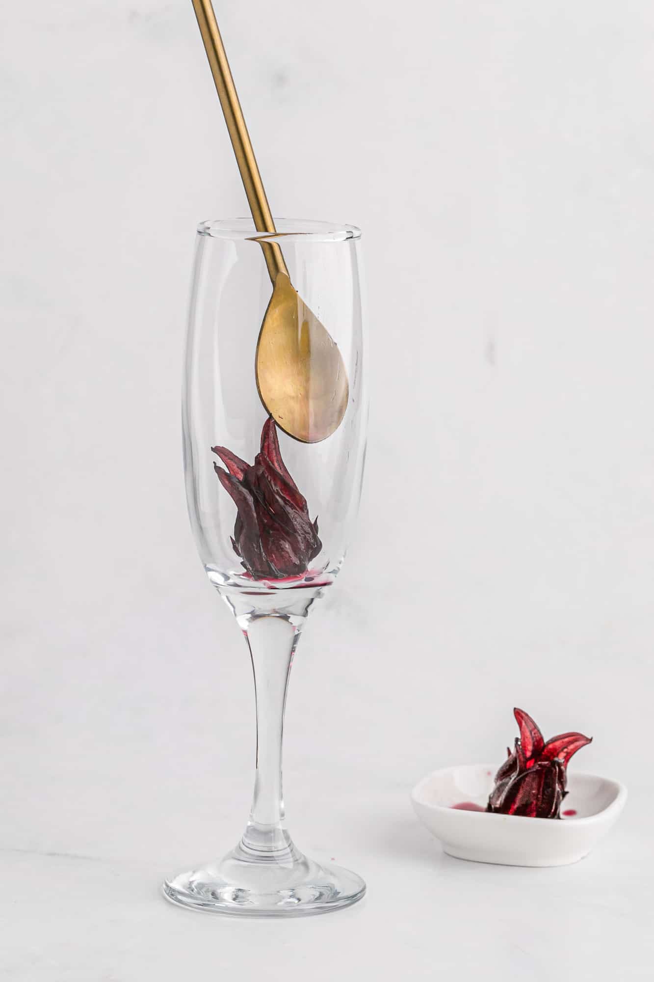 Hibiscus flower being placed in a champagne flute.