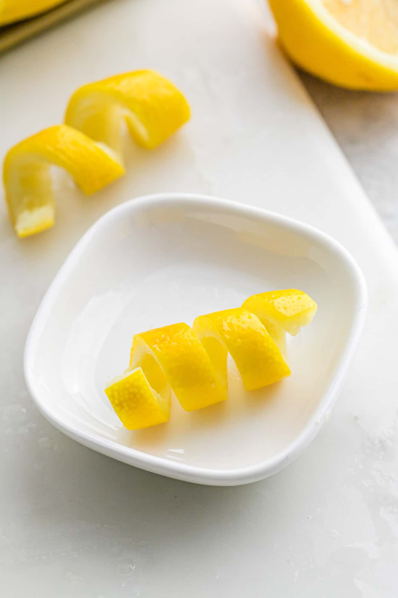 Lemon peel twist in a small white bowl.