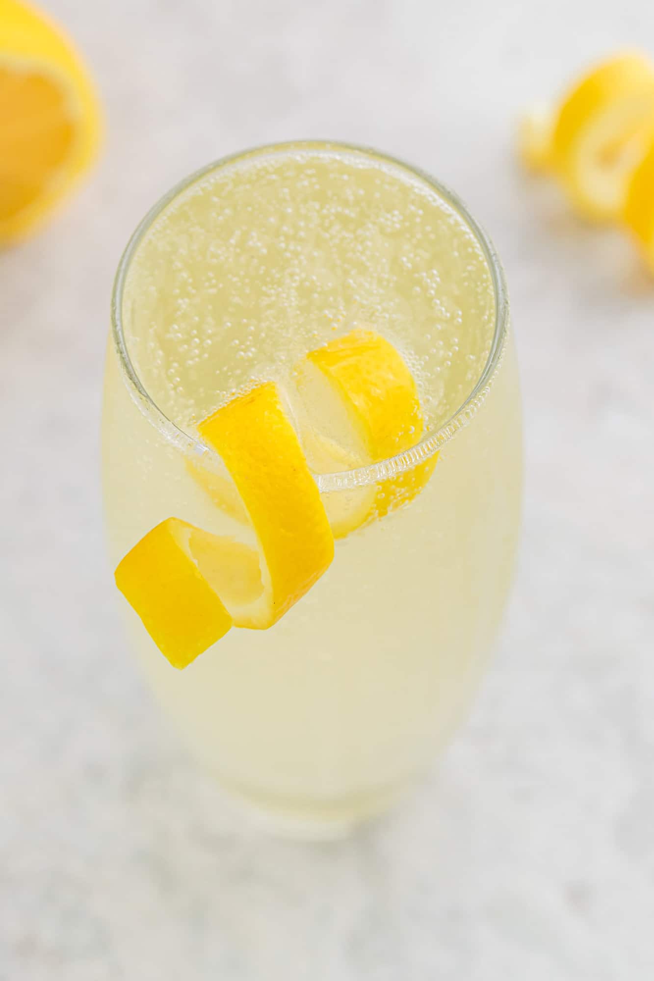 Lemon twist on a glass of lemon beverage.
