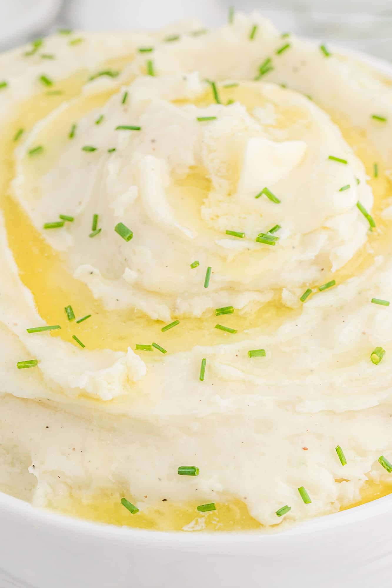 Mashed potatoes topped with butter, chives.