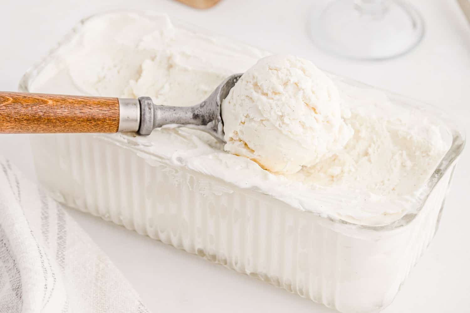 Vanilla ice cream being scooped from a loaf pan.