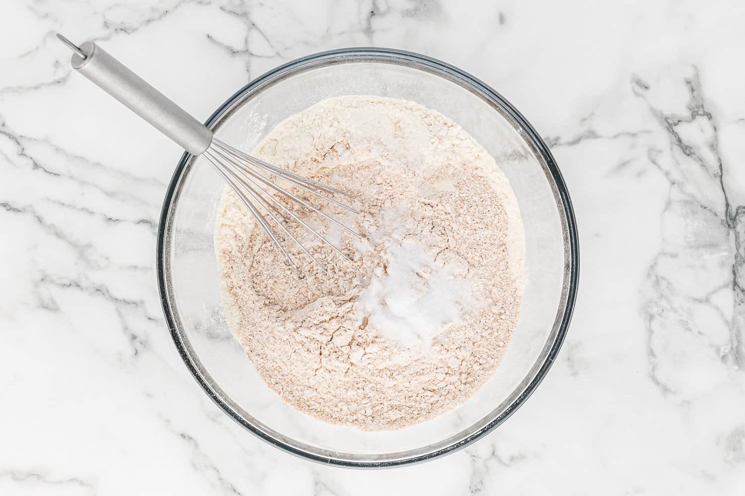 Dry ingredients in glass mixing bowl.