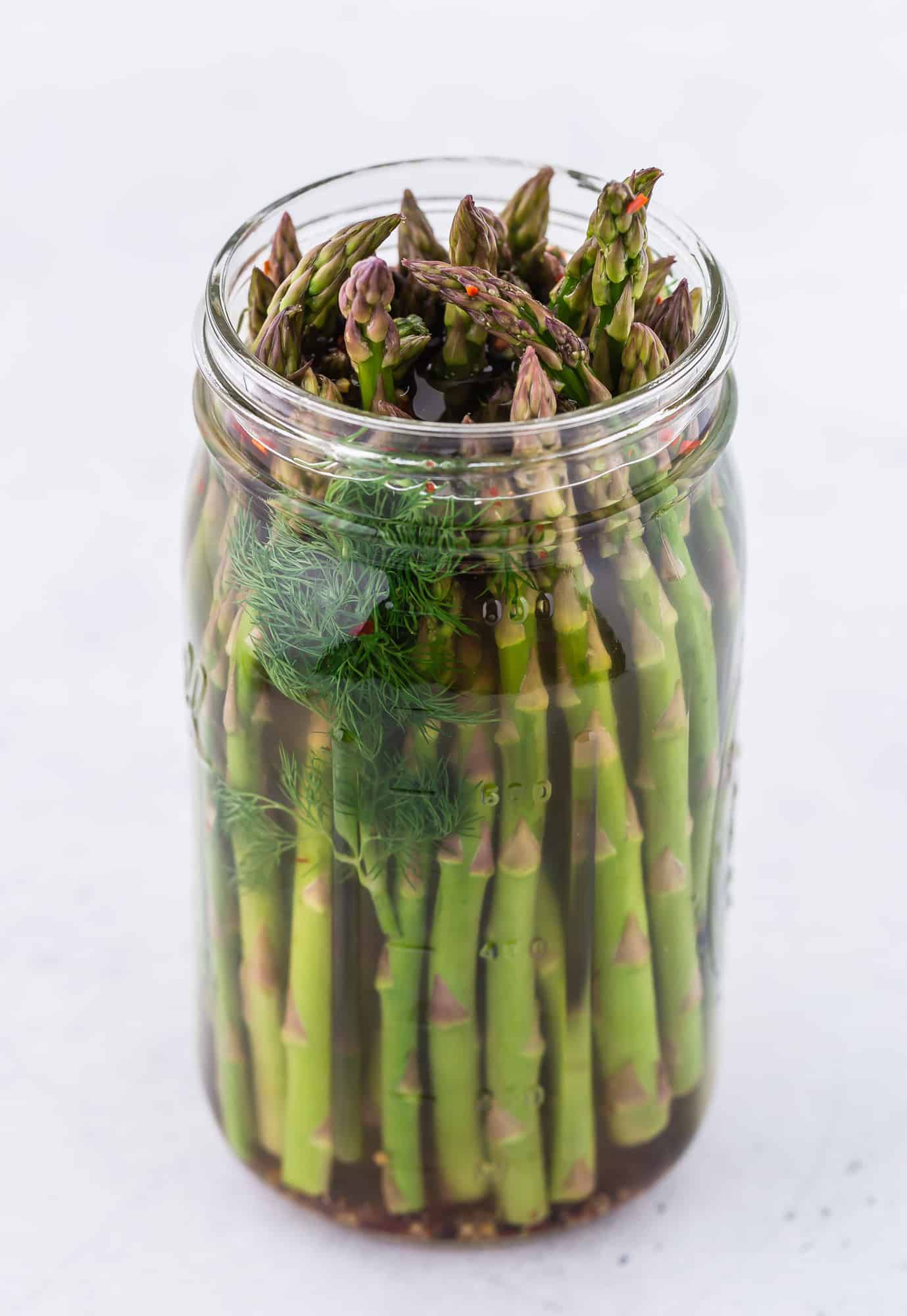 Image of asparagus pickles in a quart size mason jar.