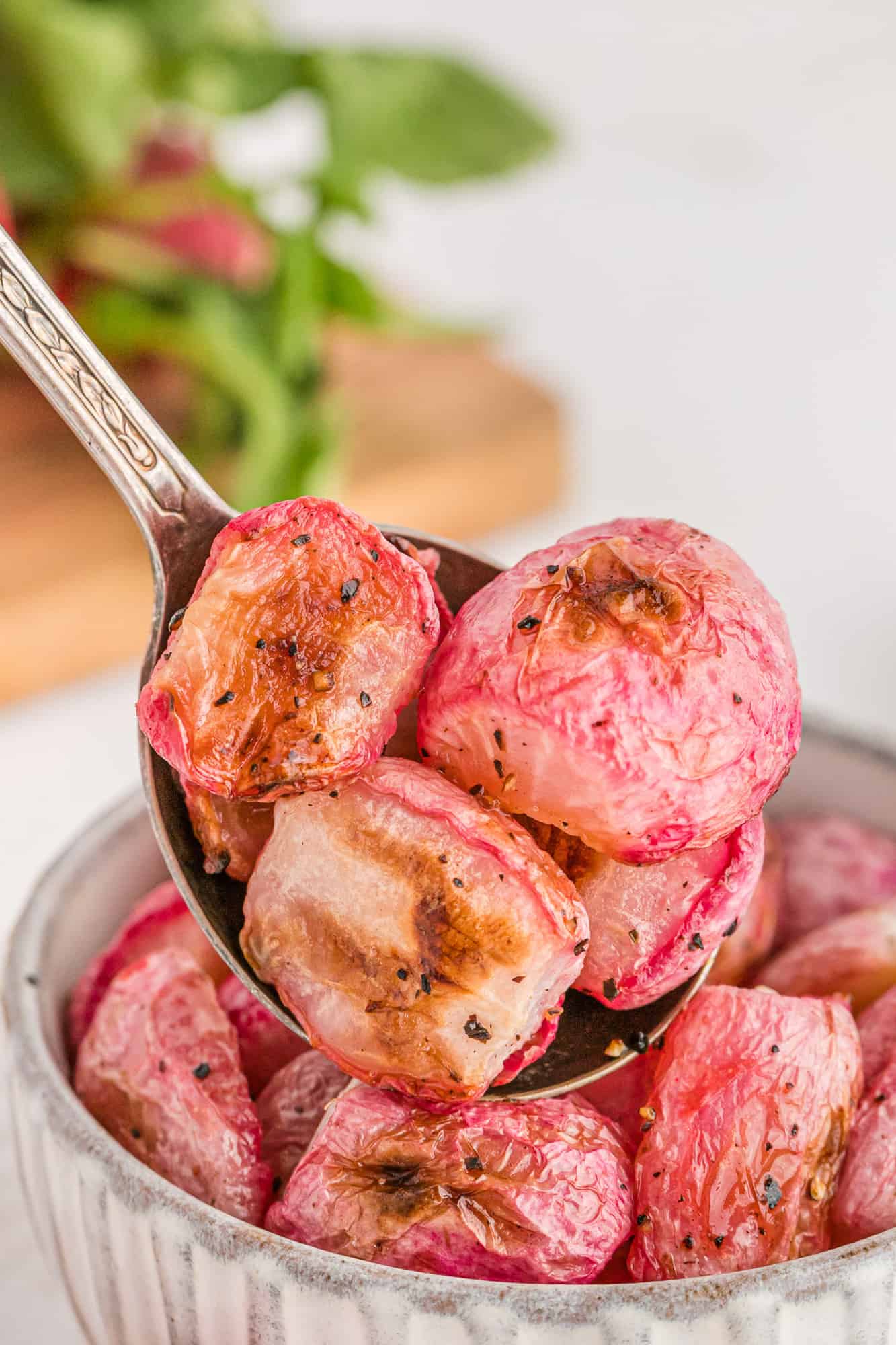 Roasted radish halves on a serving spoon.