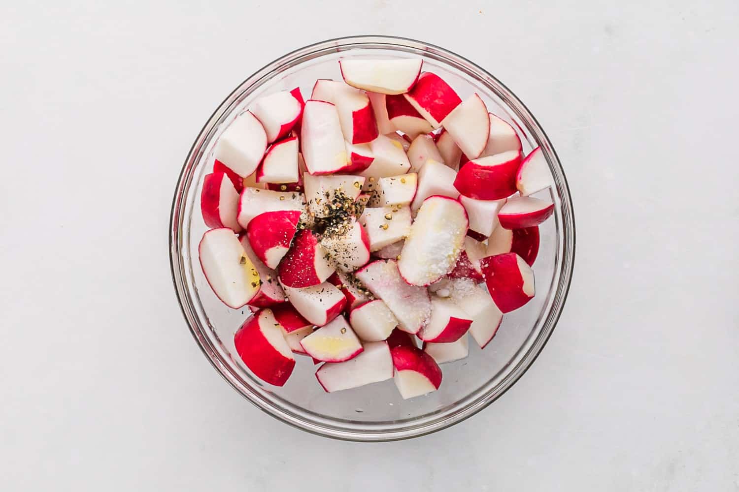 Radishes cut in half and mixed with salt and pepper.