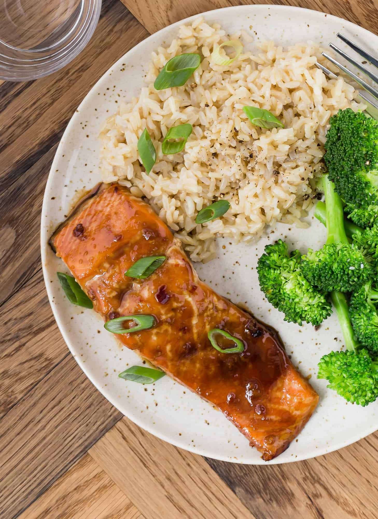 Soy glazed salmon on a plate with broccoli and rice.