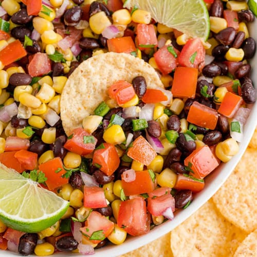 Black bean corn salsa in a bowl with a chip.