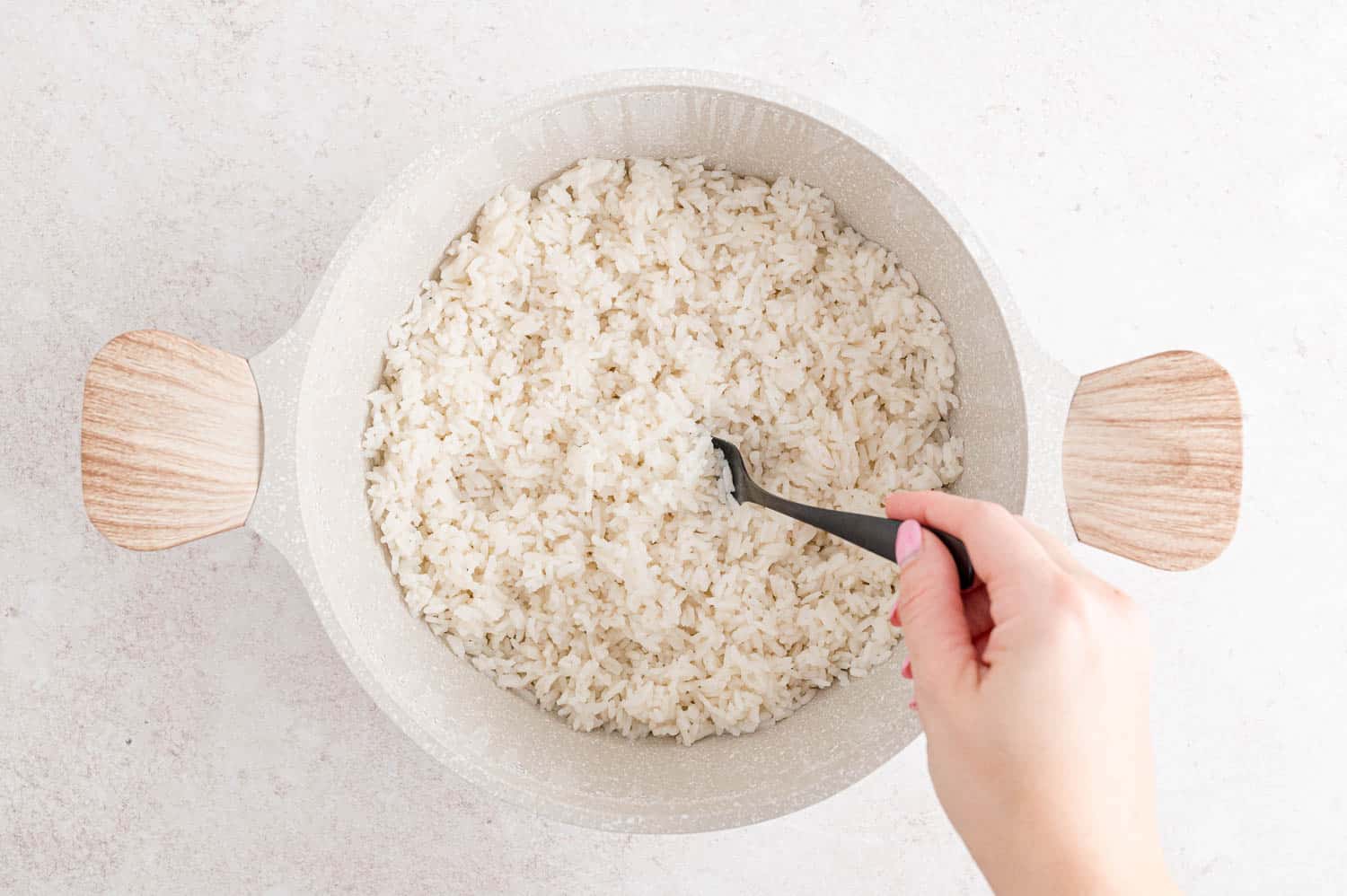 Rice being fluffed with a fork.