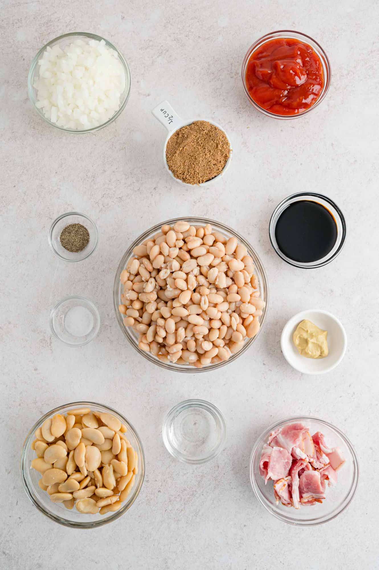 Overhead view of ingredients including beans, bacon, and brown sugar.