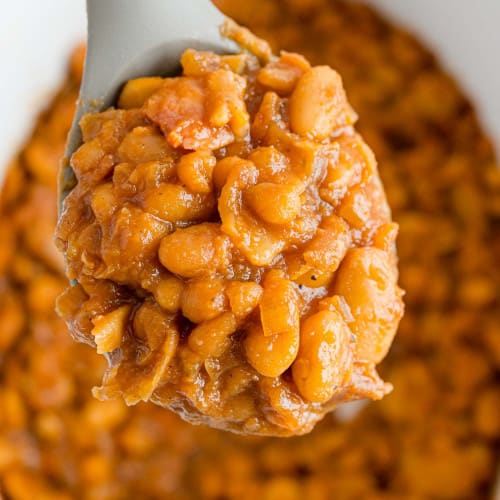 Spoonful of crock pot baked beans held over more.
