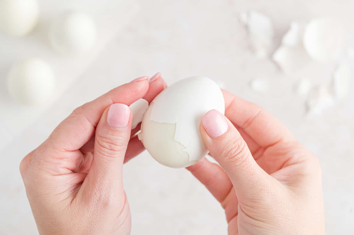 Boiled egg being peeled.