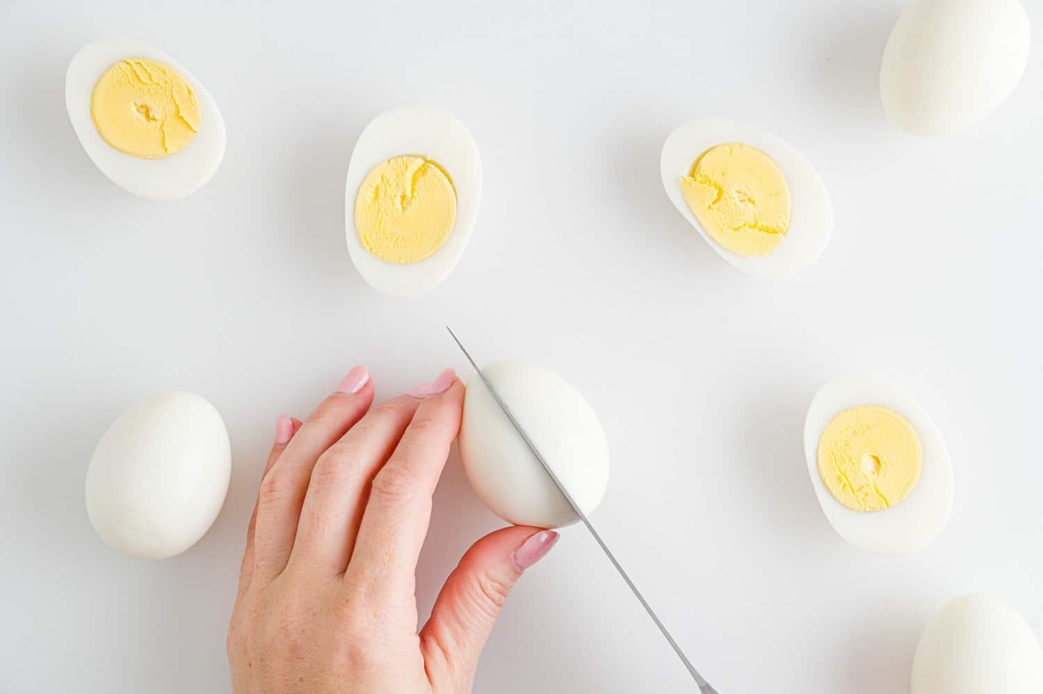Boiled eggs being cut in half.