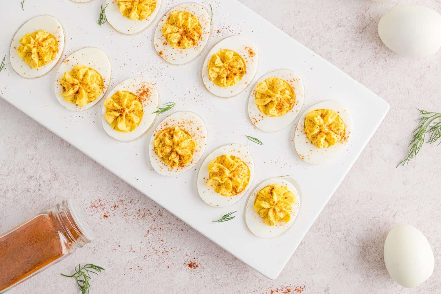 Deviled eggs garnished with paprika and dill.