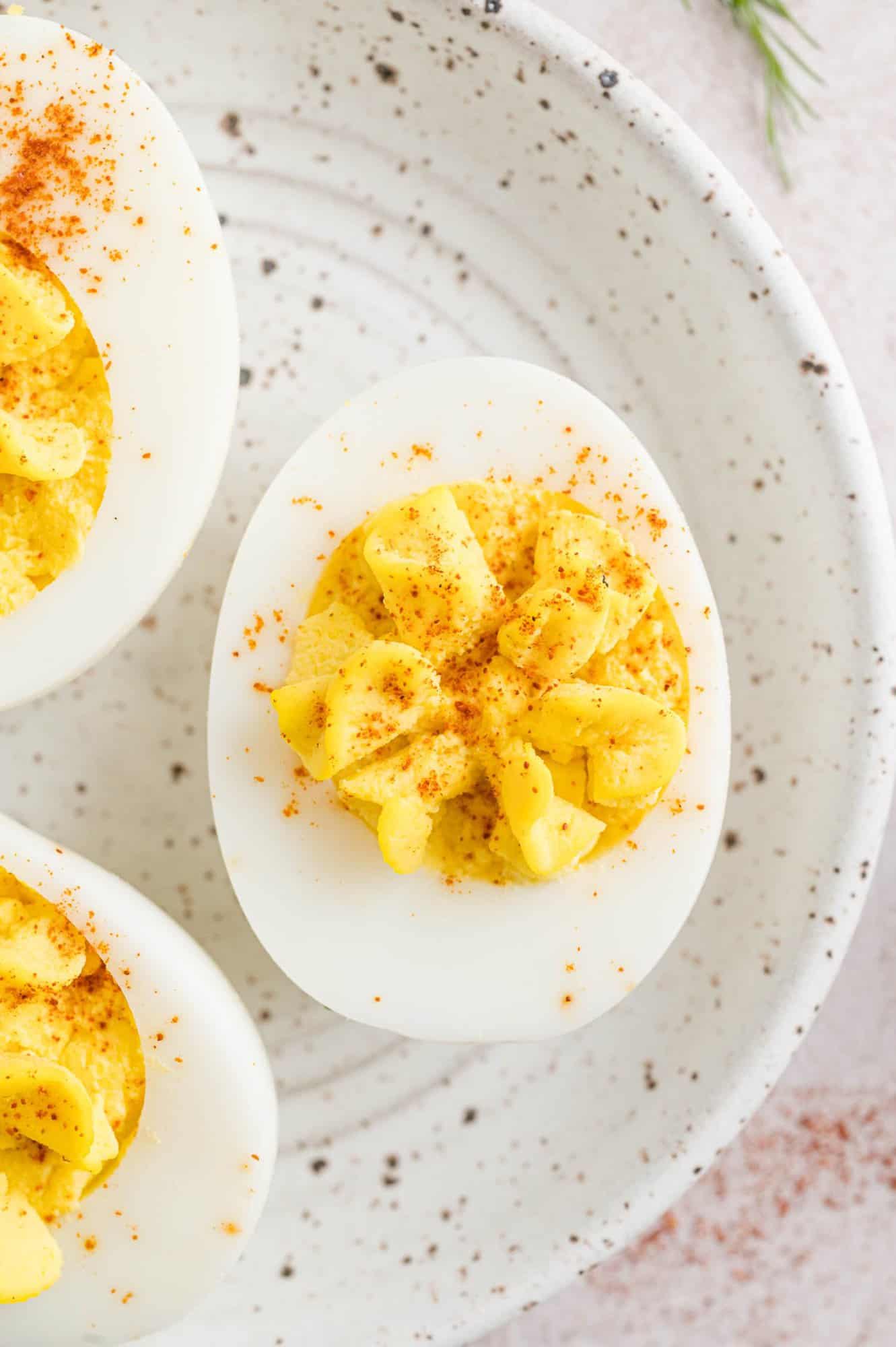 Deviled eggs on a speckled plate.