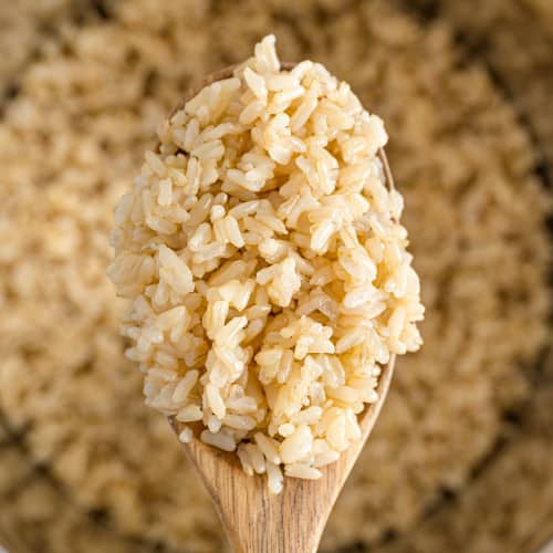 Close up of instant pot brown rice on a wooden spoon.