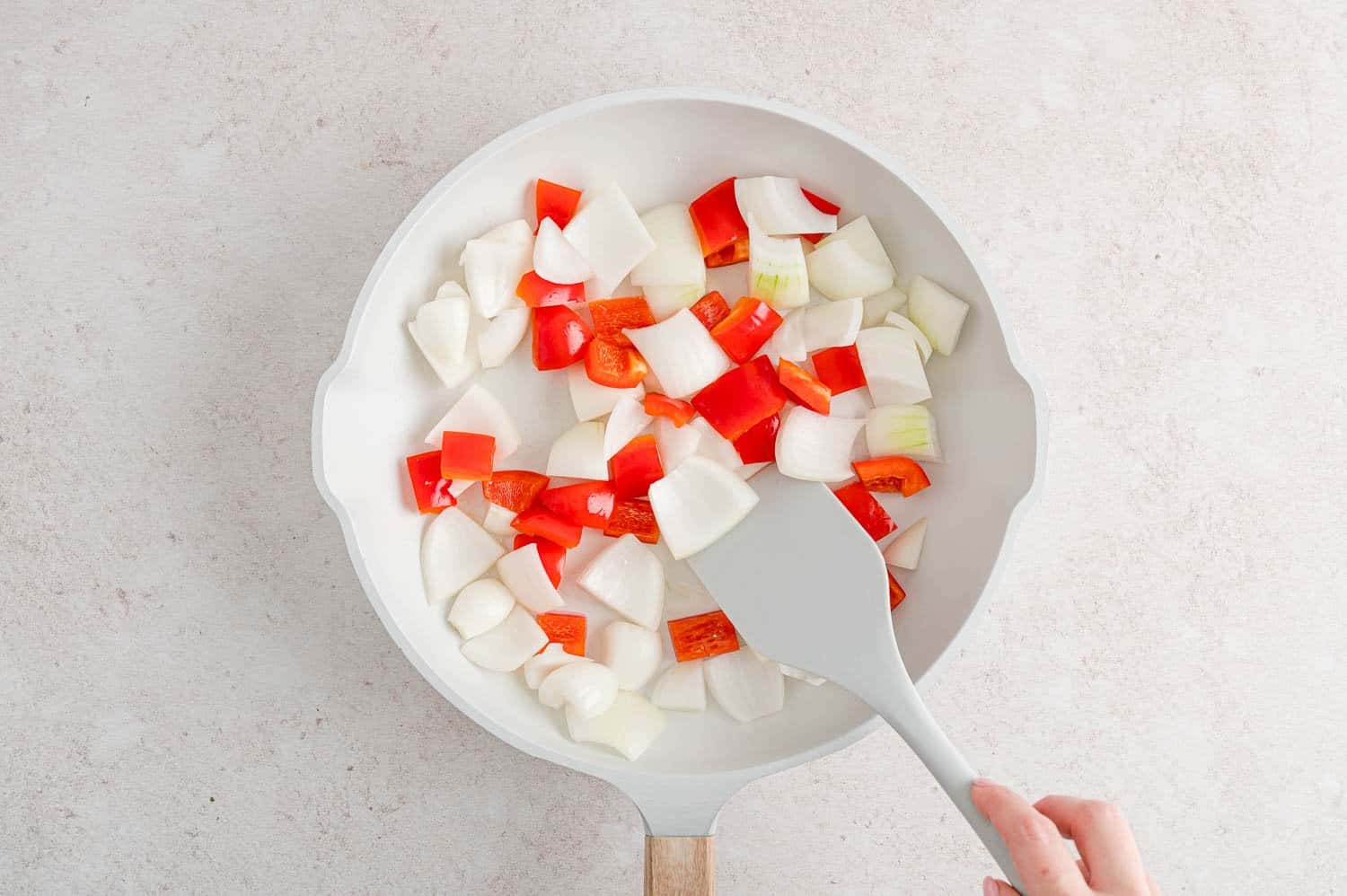 Peppers nad onions in a frying pan.