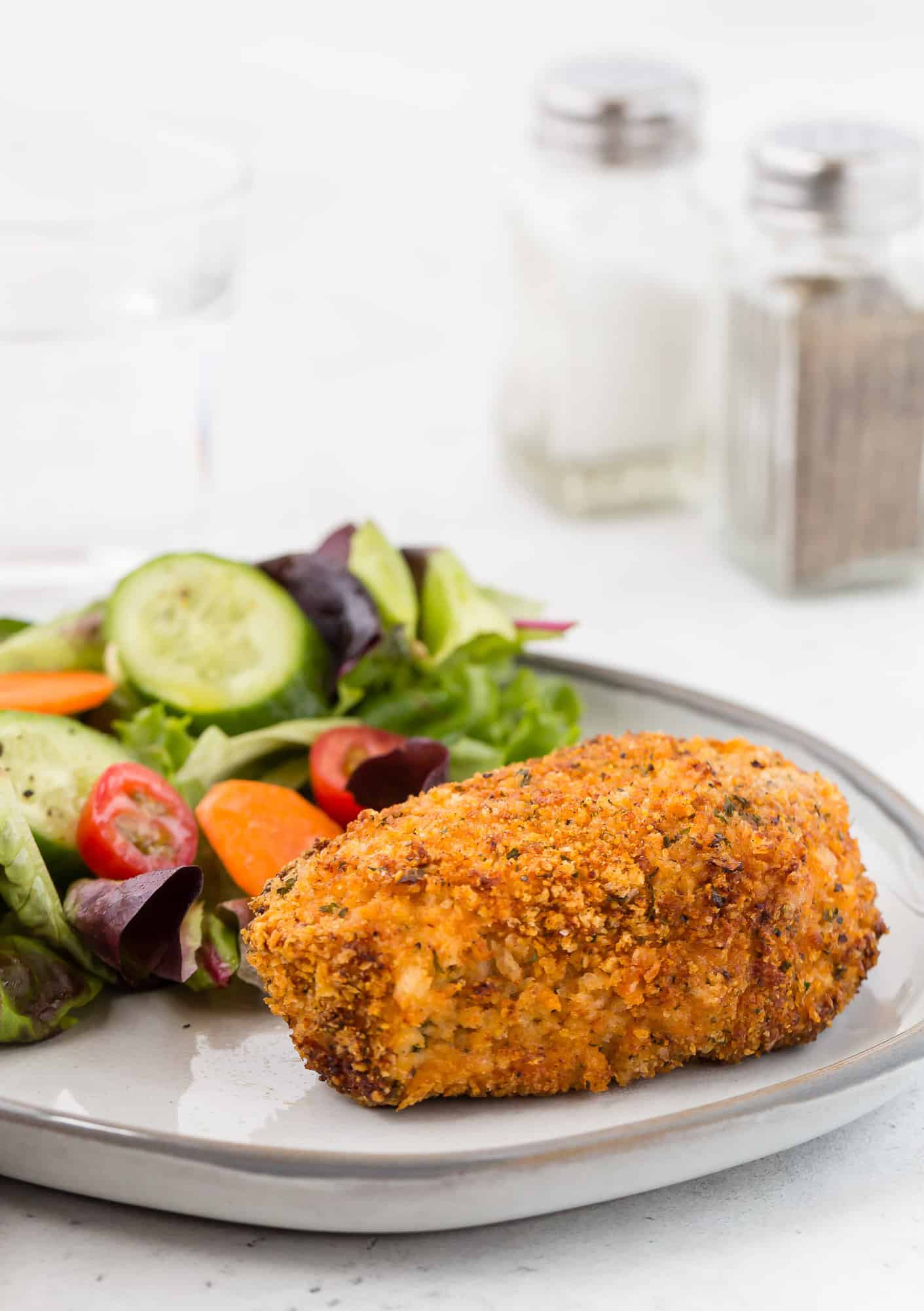 Golden brown breaded pork chop on a plate.