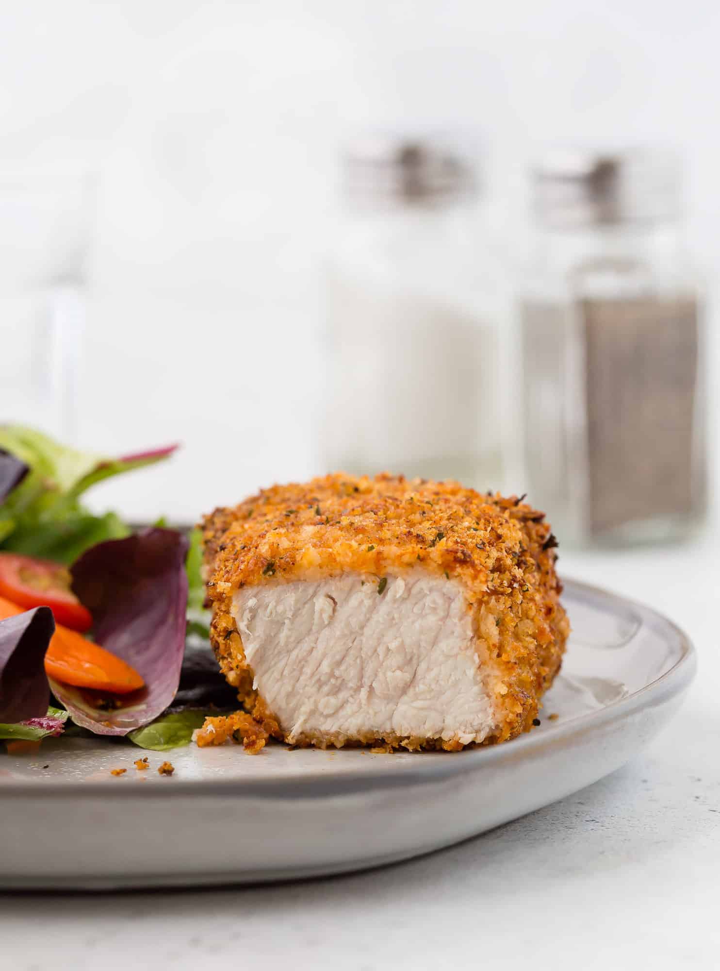 Pork chop, cut to show meat inside breading.