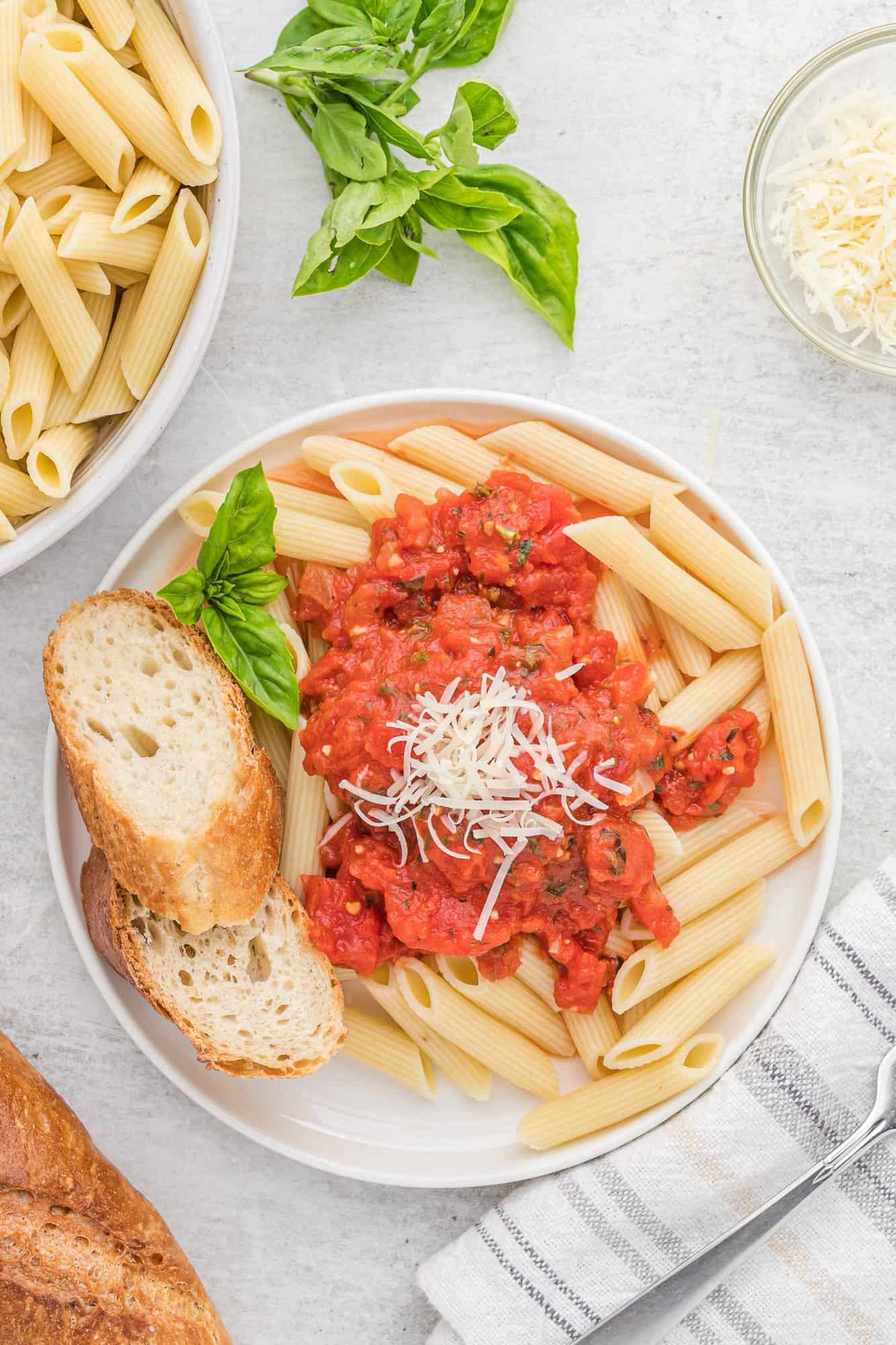 Arrabbiata sauce on pasta with cheese and bread.