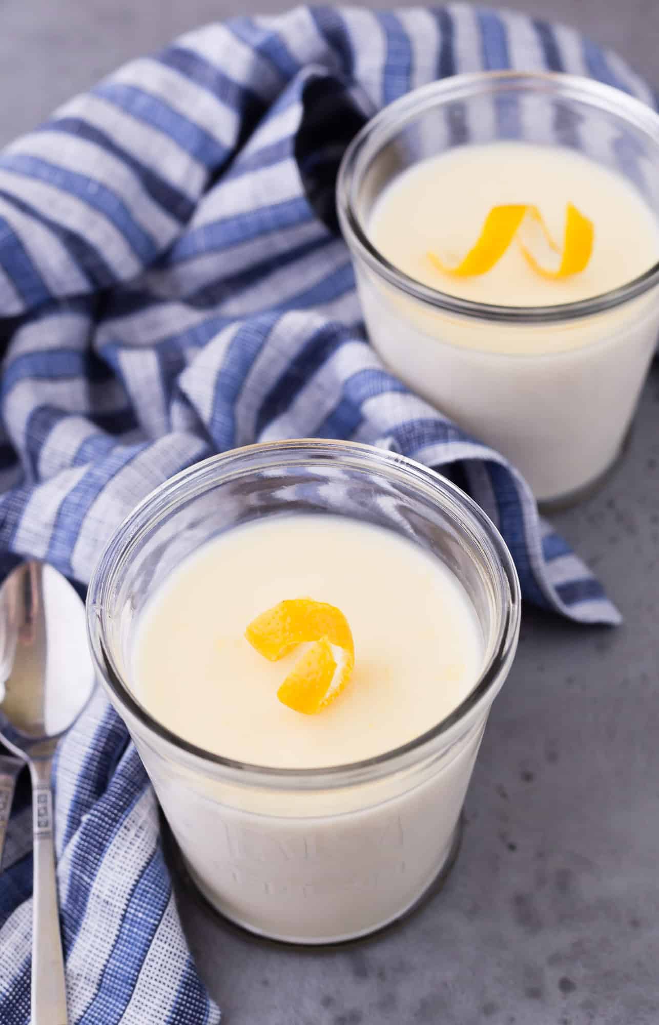 Two small servings of lemon pudding garnished with lemon twists.