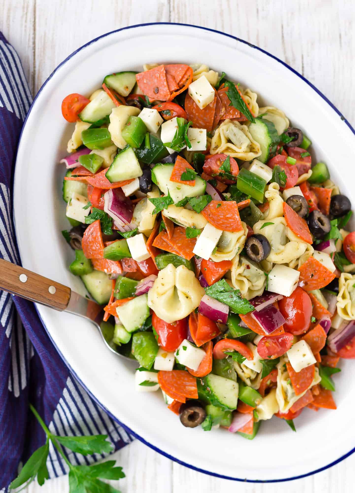 Overhead view of tortellini pasta salad with cheese, pepperoni, and vegetables.