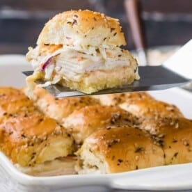 Turkey slider being lifted out of the pan on a large spatula.