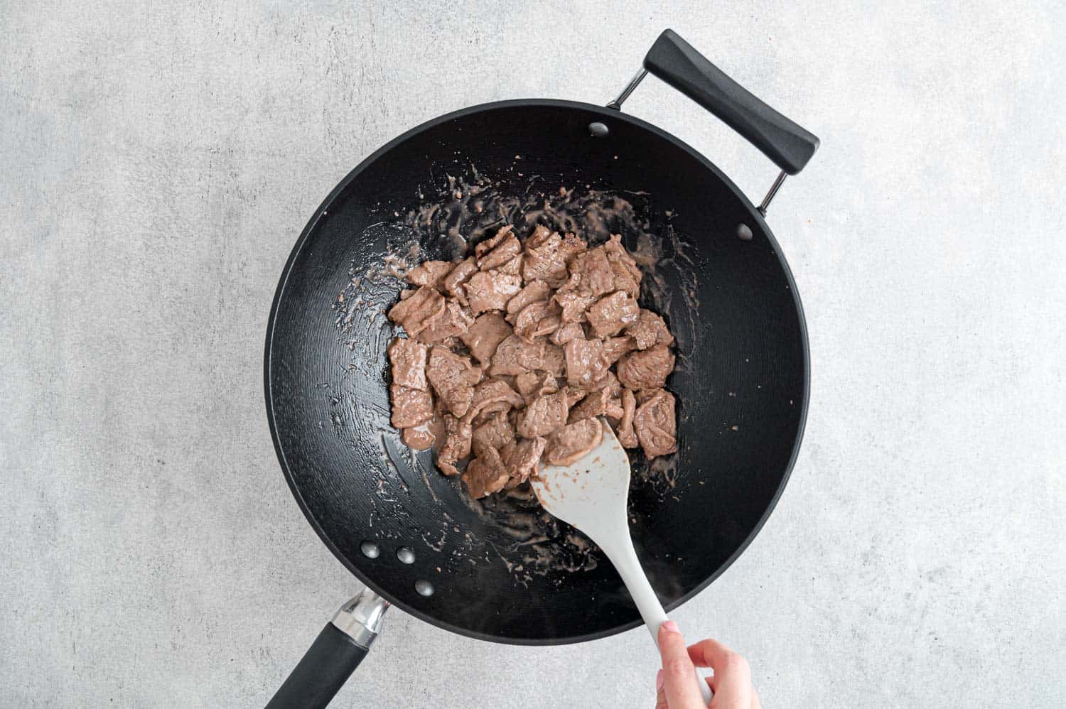 Beef being cooked in a wok.