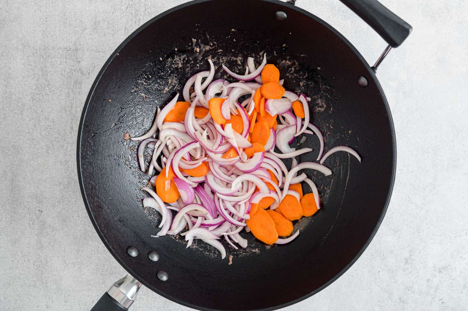 Carrots and onions in wok.