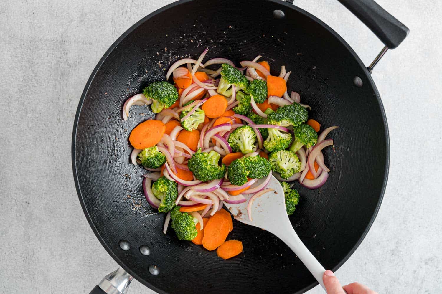 Broccoli in pan with carrots and onions.