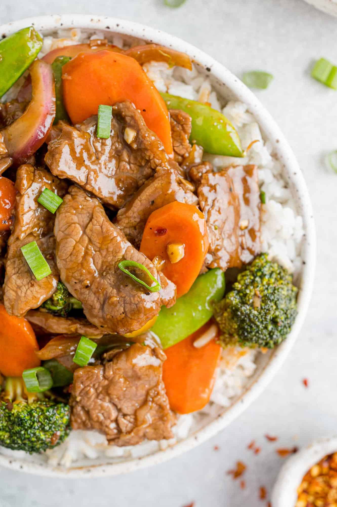 Beef stir fry with vegetables served on top of rice.