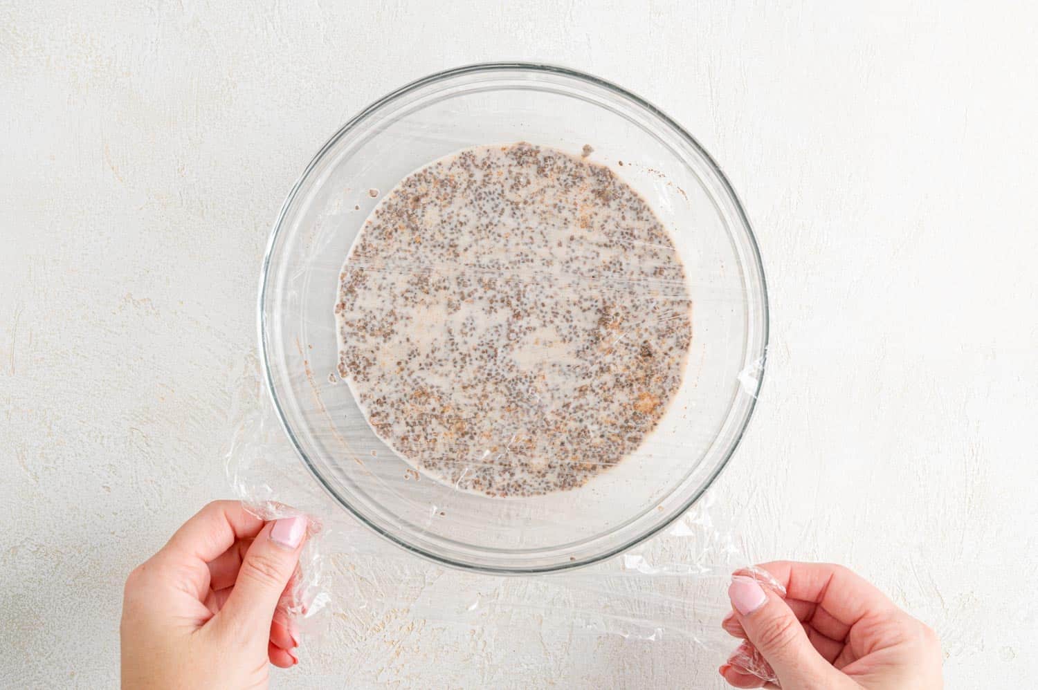 Bowl being covered with plastic wrap.