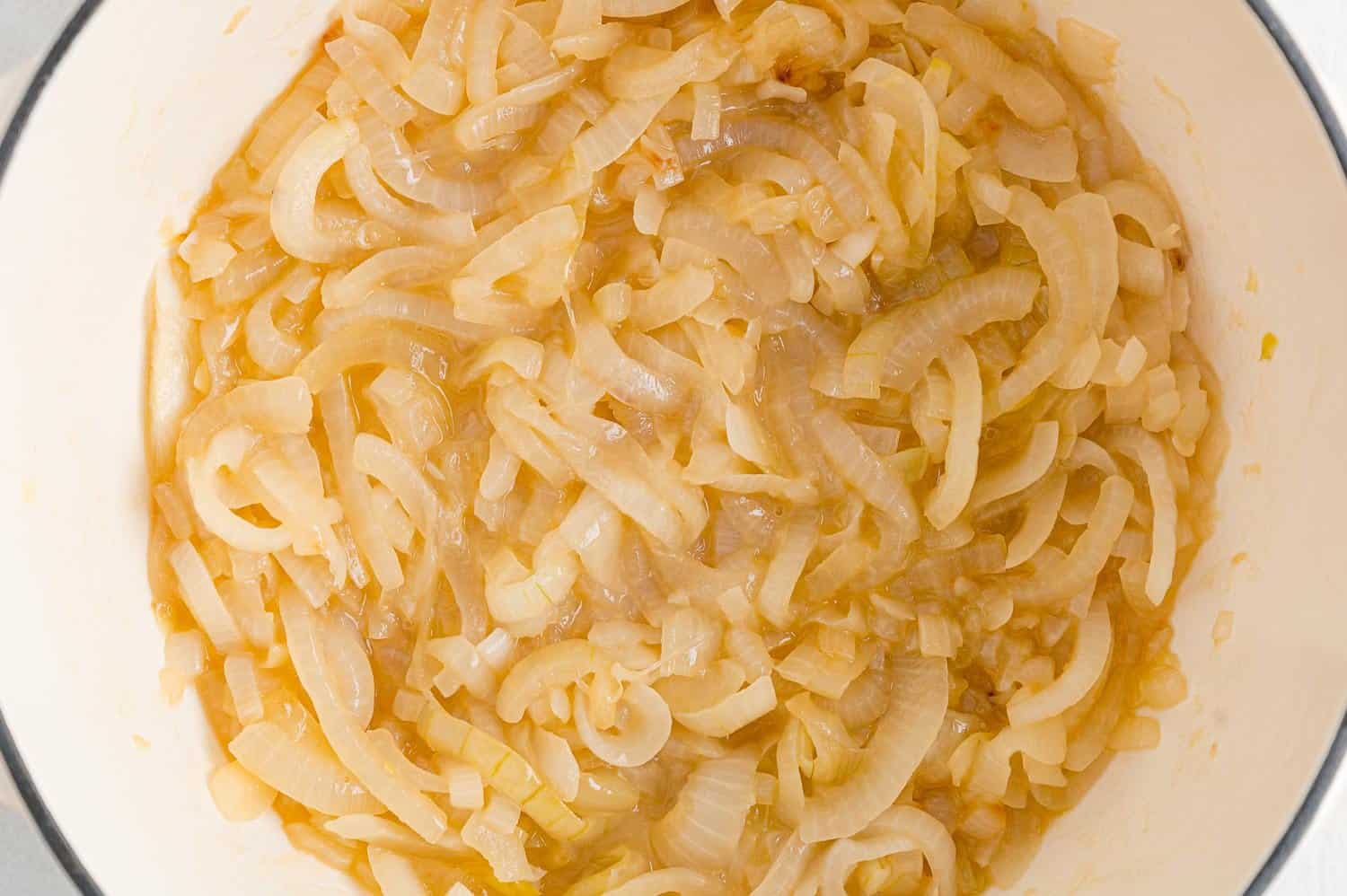 Partially cooked onions in a dutch oven.